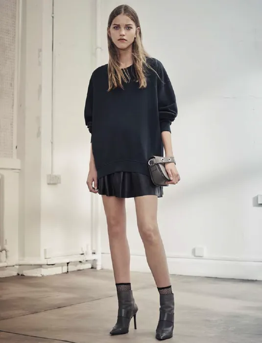 Model in a navy sweater and ruffled mini skirt