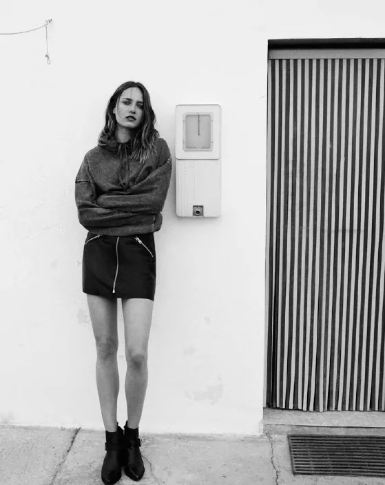 Model in a black leather mini skirt and sweater