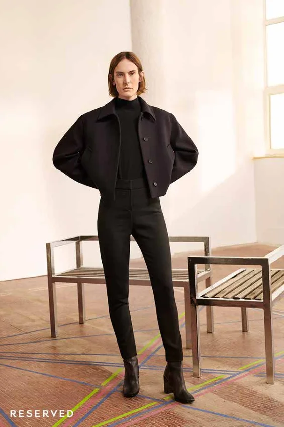 Model in a cropped black wool jacket and slim trousers