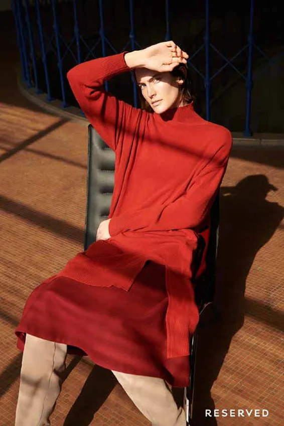 Model in a rust red knit sweater and skirt