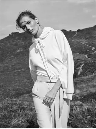 Model in a white hooded blouse and trousers, black and white