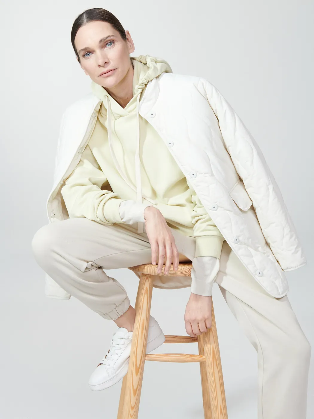 Model in cream loungewear and a quilted jacket