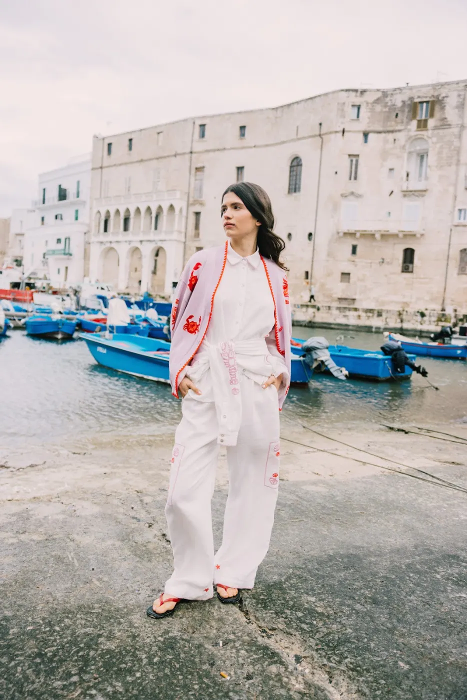 Model in a cream and pink outfit by the harbour