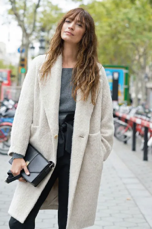 Caroline de Maigret in a cream wool coat on a city street